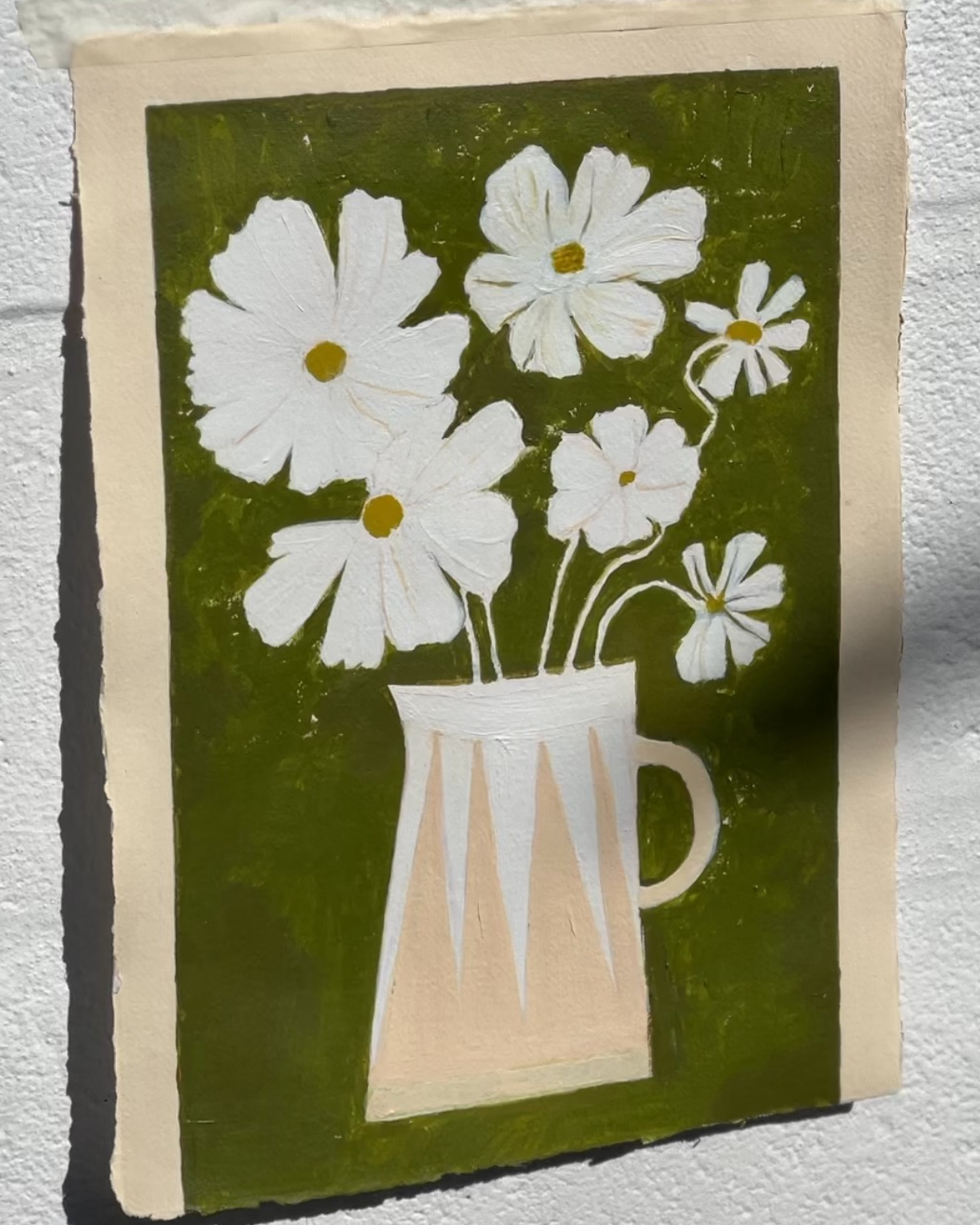 White cosmos flowers in stripe modern vase against green brushstroke background.