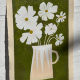 White cosmos flowers in stripe modern vase against green brushstroke background.