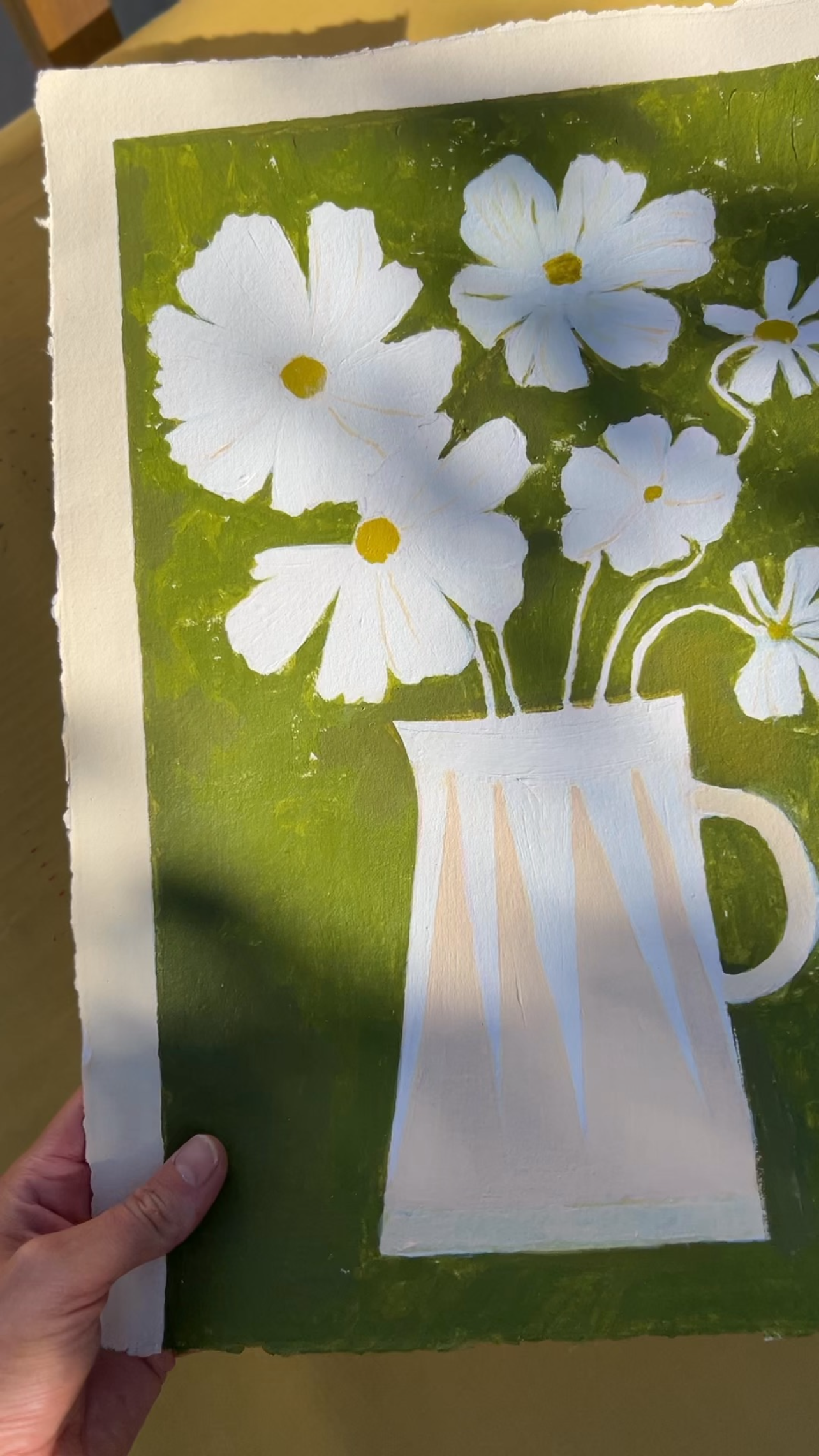 White cosmos with yellow in modern stripe vase in pink and off white with green background.