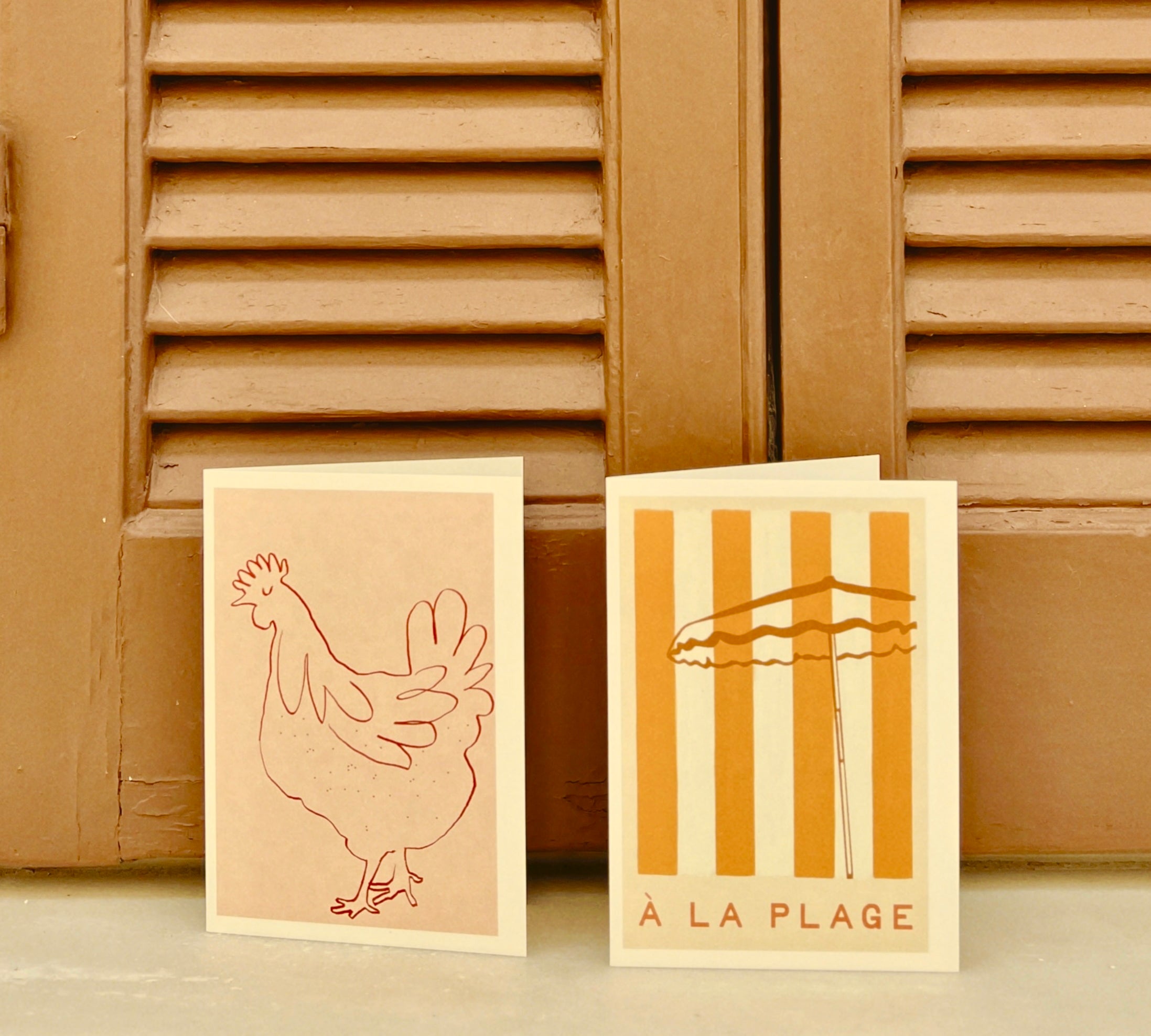 Beach greeting cards with a chicken illustration and 'A La Plage' typography by a Greek house in the Med.