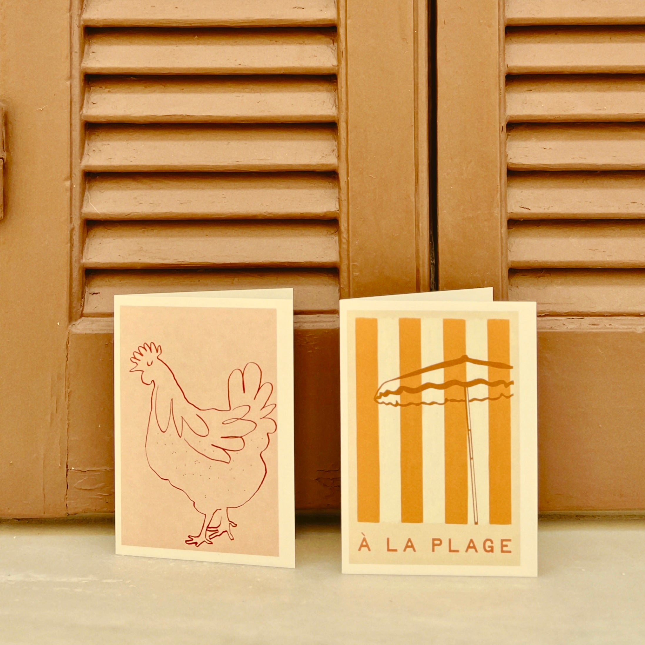 Beach greeting cards with a chicken illustration and 'A La Plage' typography by a Greek house in the Med.