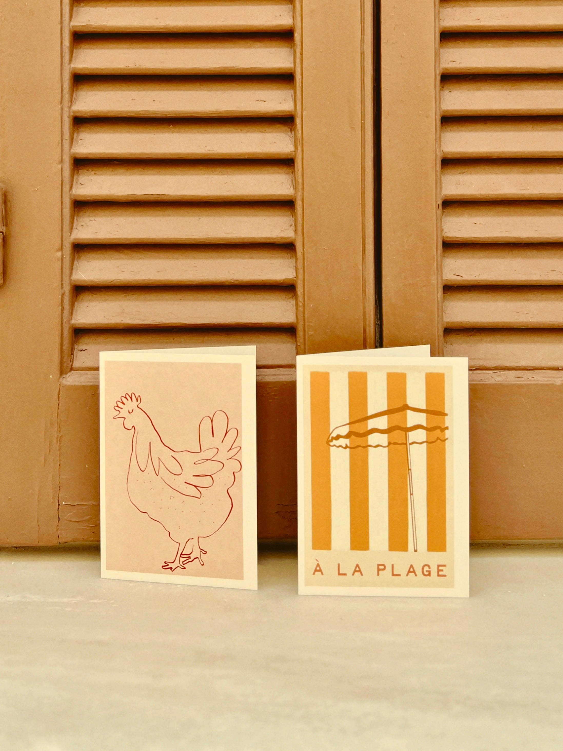 Beach greeting cards with a chicken illustration and 'A La Plage' typography by a Greek house in the Med.
