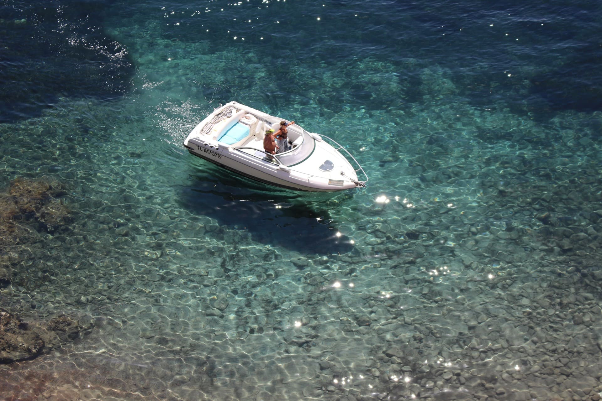 lovers on sailing boat head back to mediterranean harbour in crystal blue water
