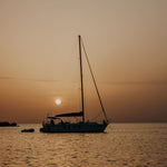 sail boat with mast anchored at sunset floating on med sea