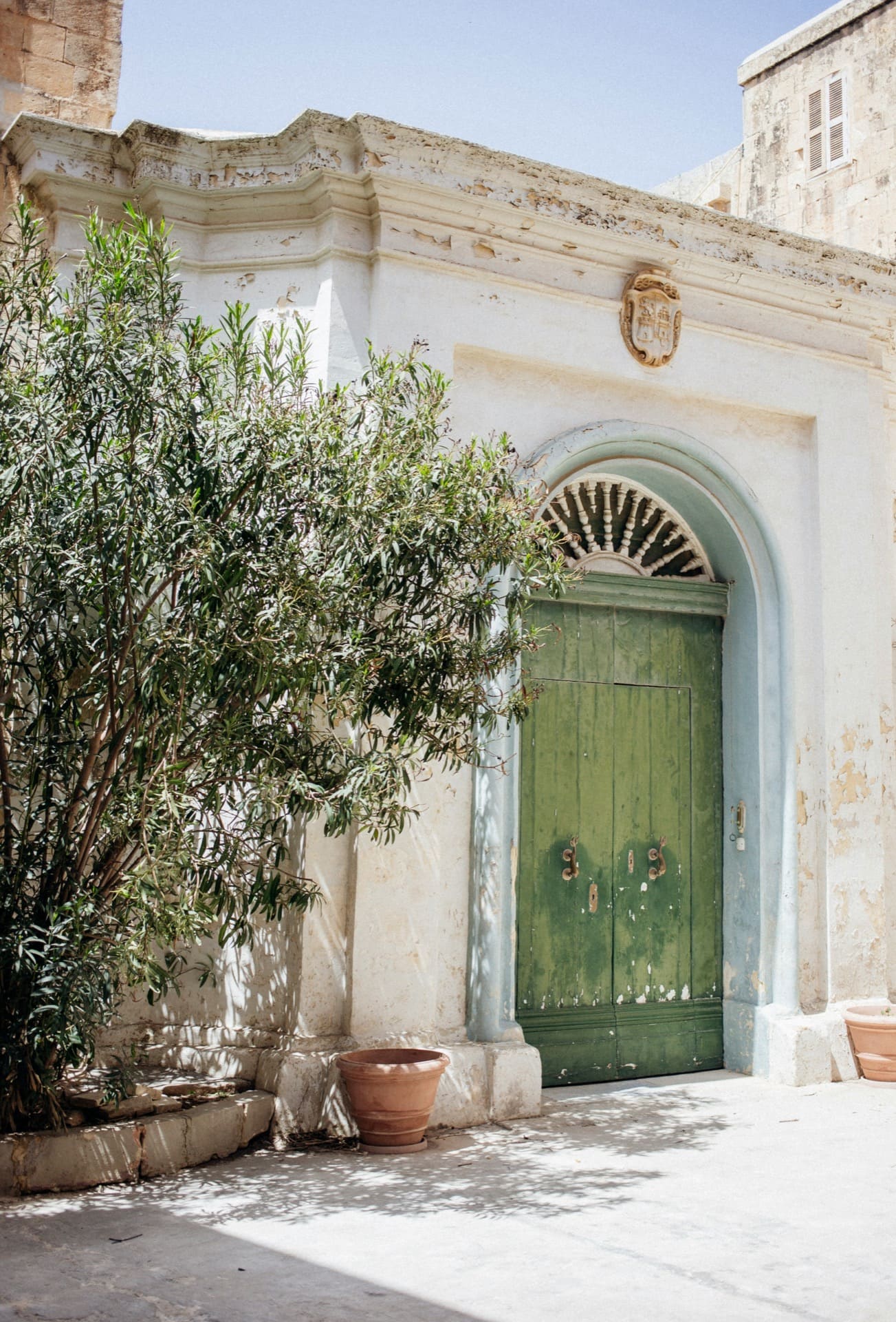 hot stylish mediterranean old town building with khaki green vintage doors