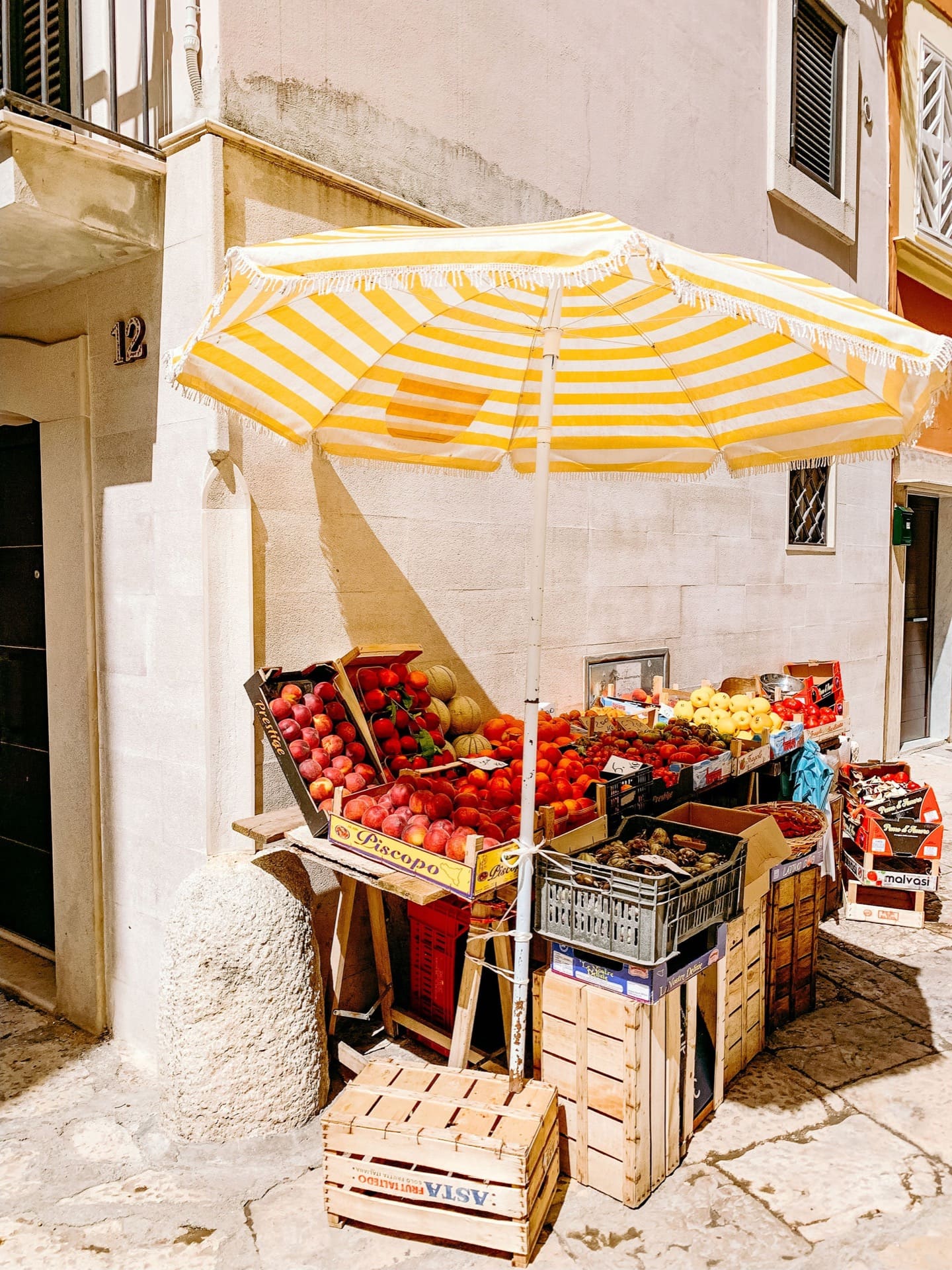 yellow stripe parasol umbrella shading fresh italian med tomatoes peaches and lemons in old town italy