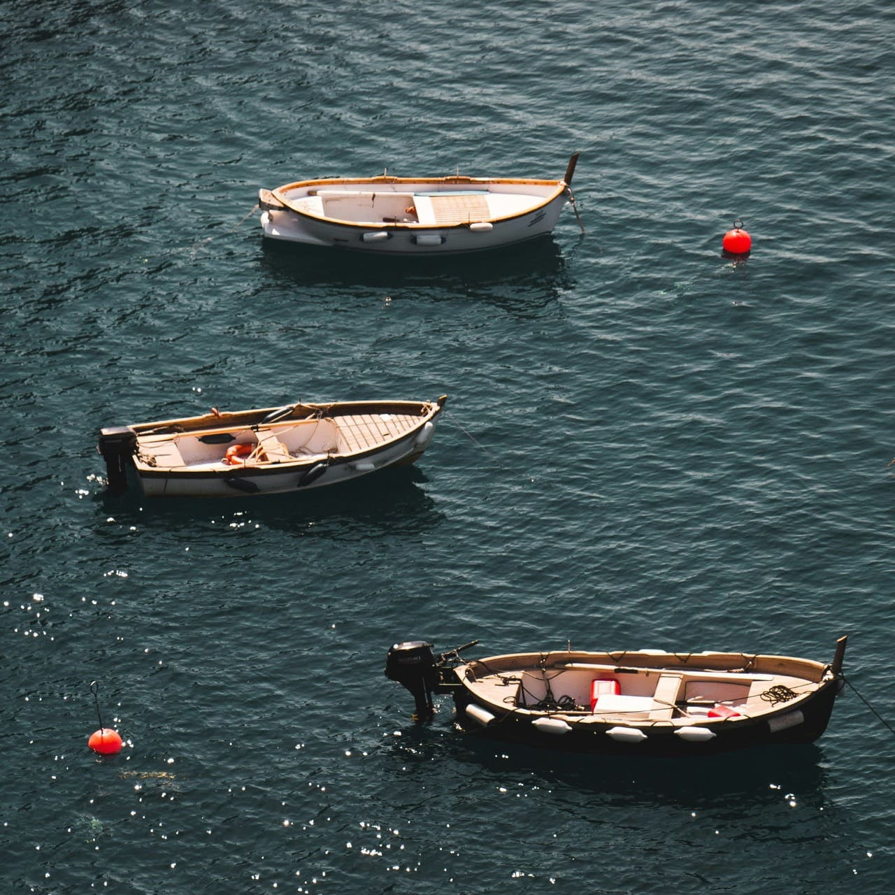 wood boats and neon buoys in crystal blue mediterranean sea