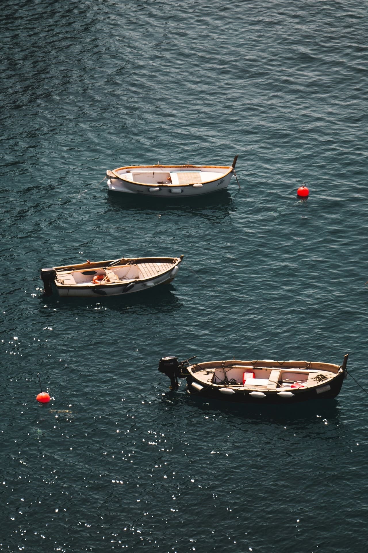 wood boats and neon buoys in crystal blue mediterranean sea