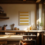 puglia beach club stripe giclée art print of original oil painting. puglia beach club stripe is a replica of the famous beach cloth linen that lines mediterranean coastlines. in a deep golden yellow ochre with rough mark my words font scribbled in crayon to the right hand side. Art print is hung in a traditional italian wooden beam kitchen in the hills of tuscany. the kitchen features rustic wood, local pottery and traditional utensils. it is bright and sun drenched.